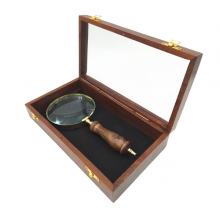 Magnifying glass in a wooden box with a glass top