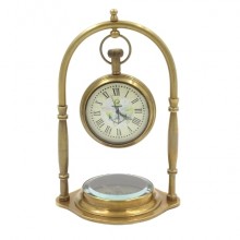 Brass clock on an arch with a compass