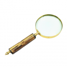 Magnifying glass in a brass frame with a bone ...
